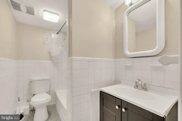 a bathroom with a sink toilet and a mirror