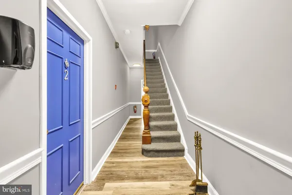 a view of staircase with lots of frames on wall and a window