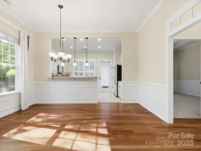 a view of a kitchen with wooden floor and a window