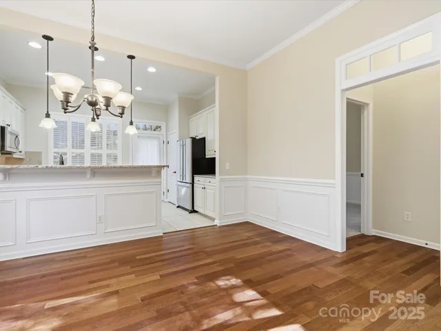 a view of a room with wooden floor and white walls