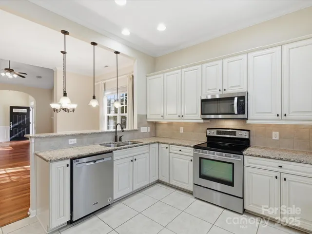a kitchen with white cabinets stainless steel appliances and sink