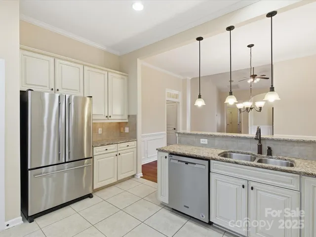 a kitchen with white cabinets and refrigerator