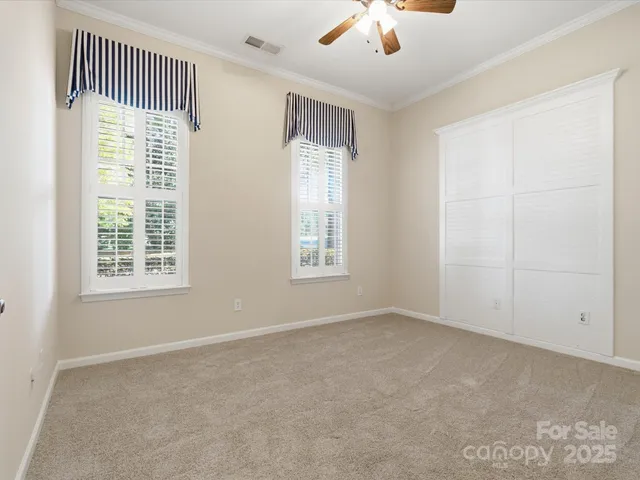 an empty room with windows and fan