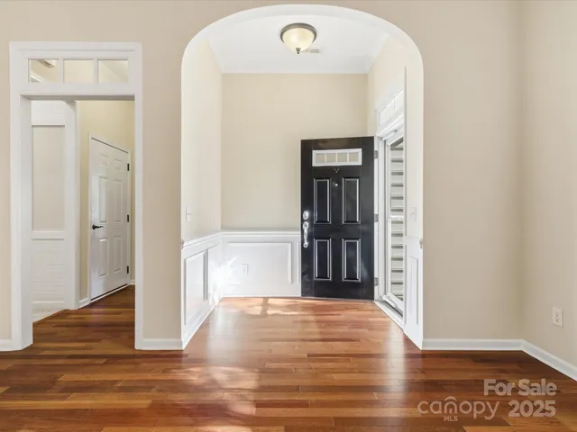 a view of a hallway with wooden floor and a living room