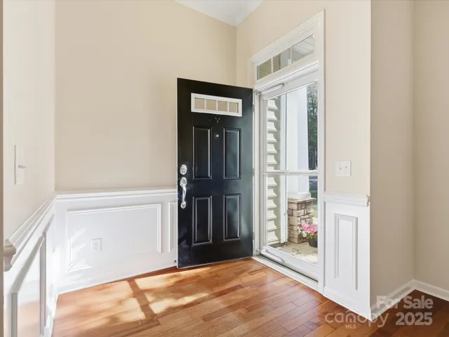 a view of a hallway with wooden floor and a room