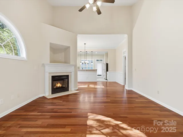 a view of empty room with wooden floor and fireplace