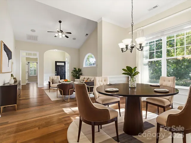 a view of a dining room with furniture a chandelier and wooden floor