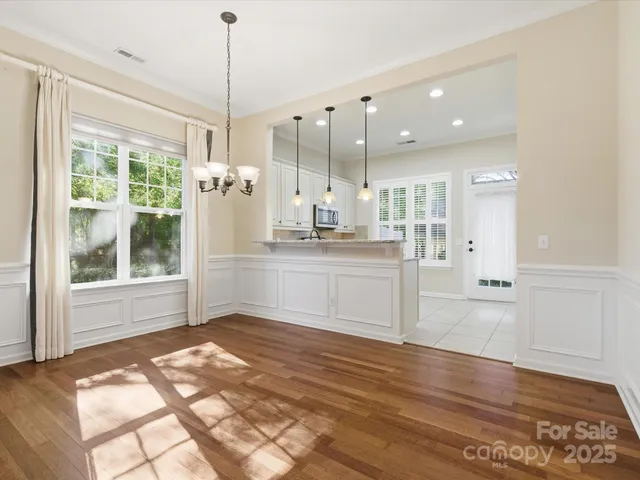 a kitchen with kitchen island a counter top space appliances and a chandelier