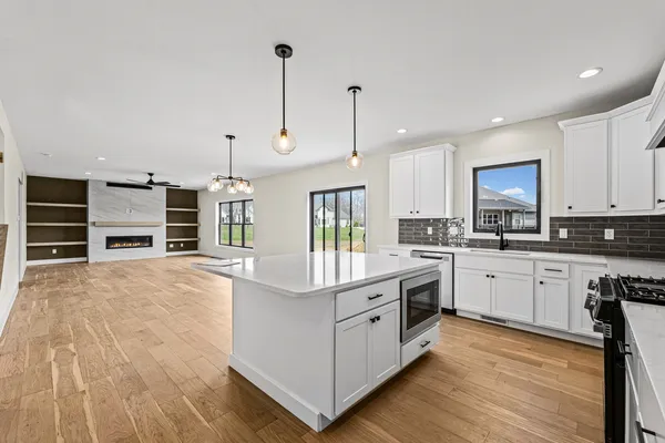 a kitchen with kitchen island a stove a sink and a wooden floors