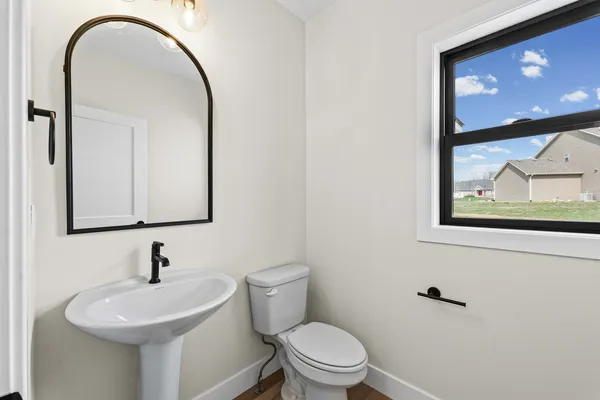 a bathroom with a toilet sink and mirror