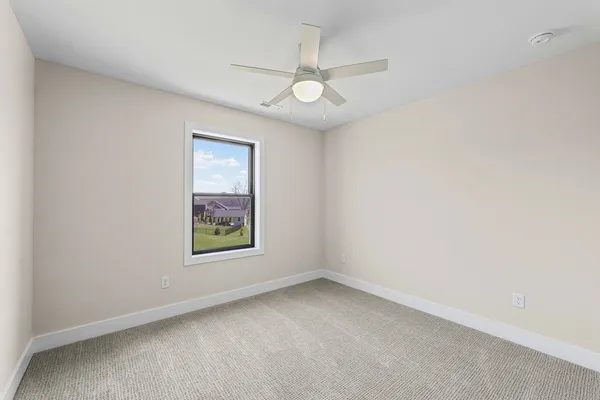 an empty room with a window and a fan
