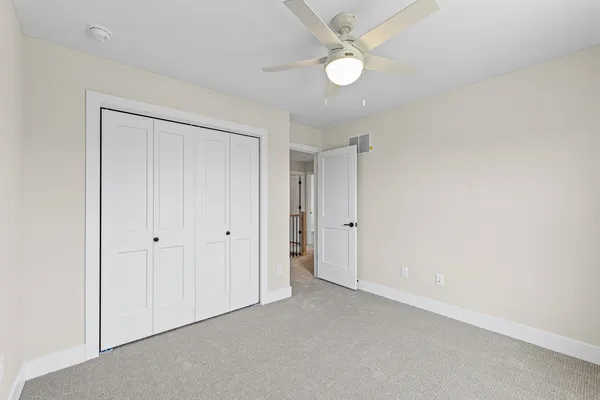 an empty room with a window and a fan