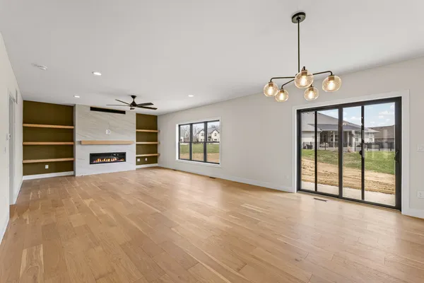 a view of an empty room with a window and fire place