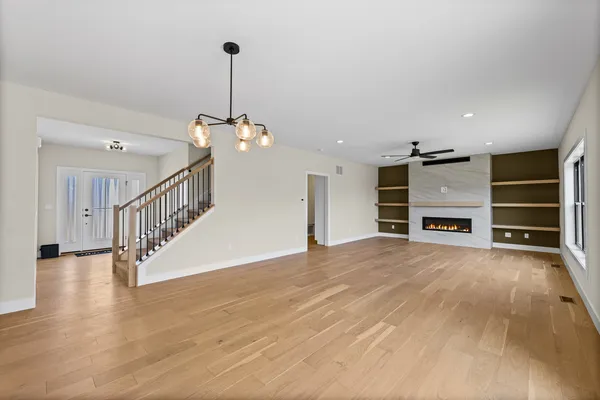 a view of a livingroom with wooden floor and a ceiling fan