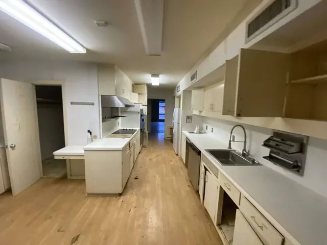 a kitchen with a sink a stove top oven and cabinets