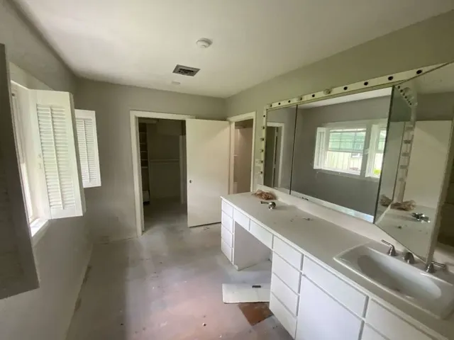 a bathroom with a tub sink and mirror