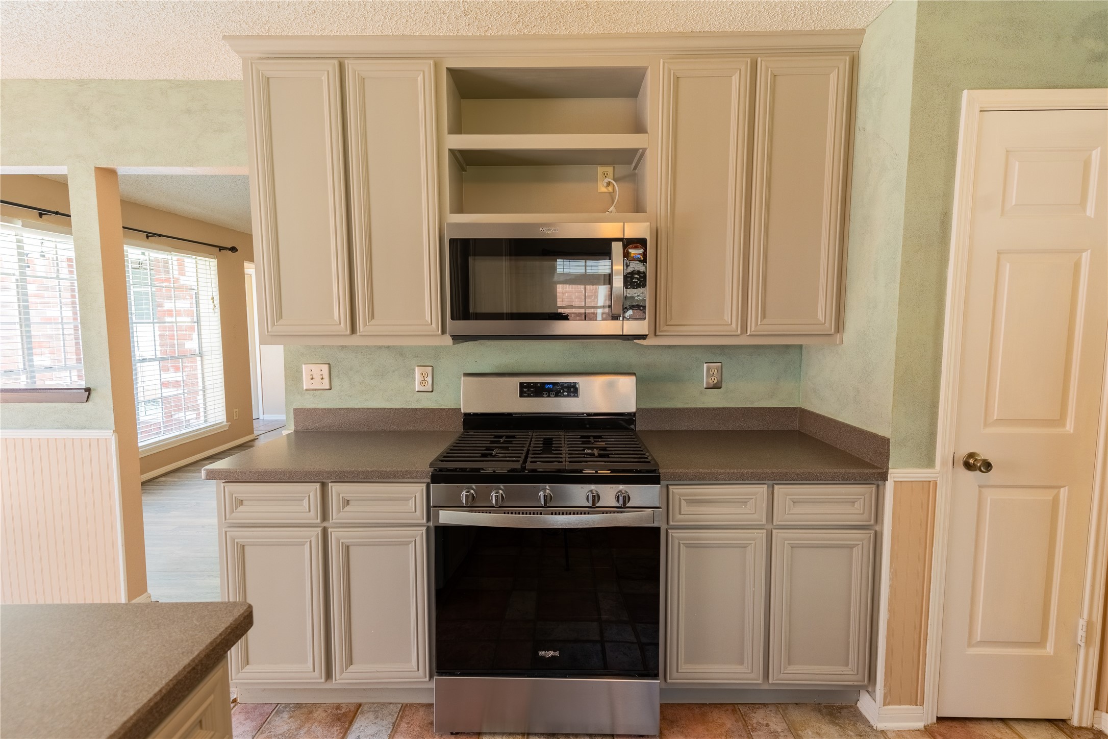 4007 Spring Forest Drive Pearland, TX 77584 - Photo 11 of 39 a kitchen with granite countertop white cabinets and black appliances