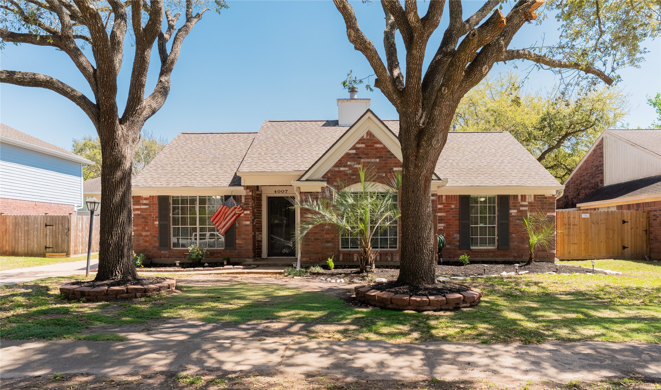 4007 Spring Forest Drive Pearland, TX 77584 - Photo 2 of 39 a view of a white house with a large tree and next to a yard