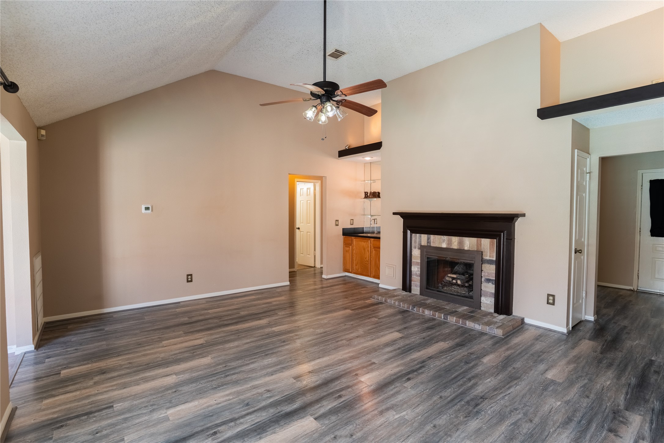 4007 Spring Forest Drive Pearland, TX 77584 - Photo 4 of 39 a view of an empty room with wooden floor and a fireplace