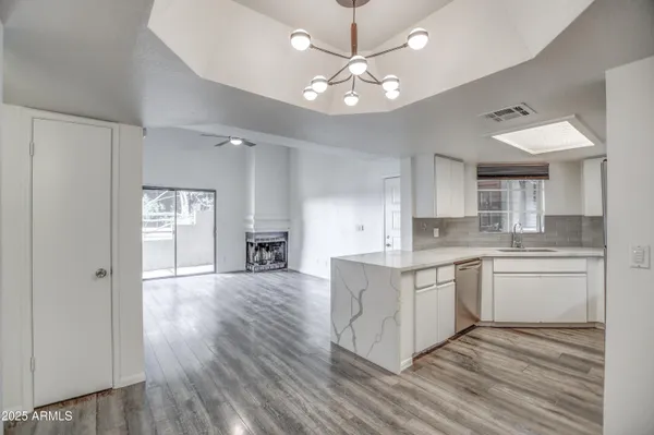 a large kitchen with cabinets wooden floor and stainless steel appliances