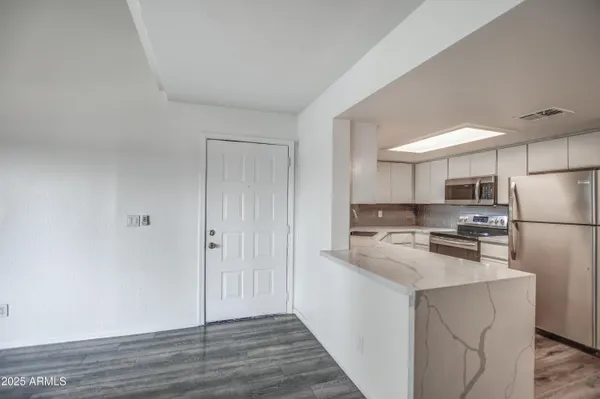 a kitchen with stainless steel appliances a refrigerator and a stove top oven