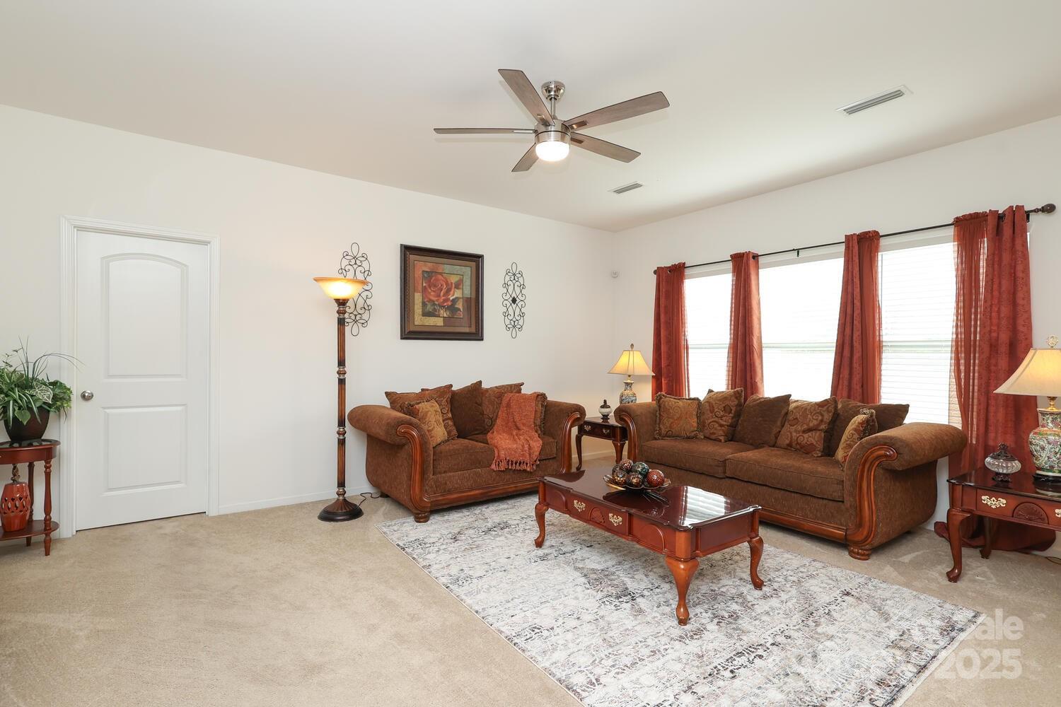 2104 Gillette Drive Clover, SC 29710 - Photo 16 of 33 a living room with furniture a large window and a ceiling fan