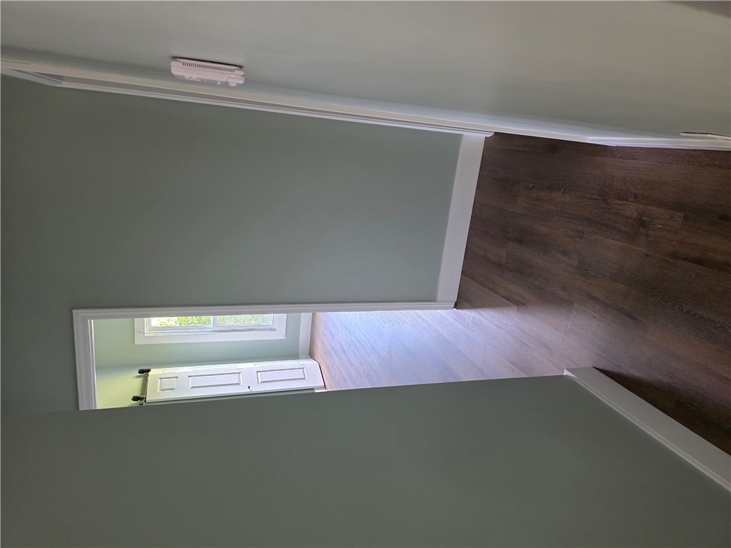 112 Simmons Street Anderson, SC 29625 - Photo 18 of 26 Rich hardwood-style flooring extends through the hallway, bathed in natural light from distant windows.