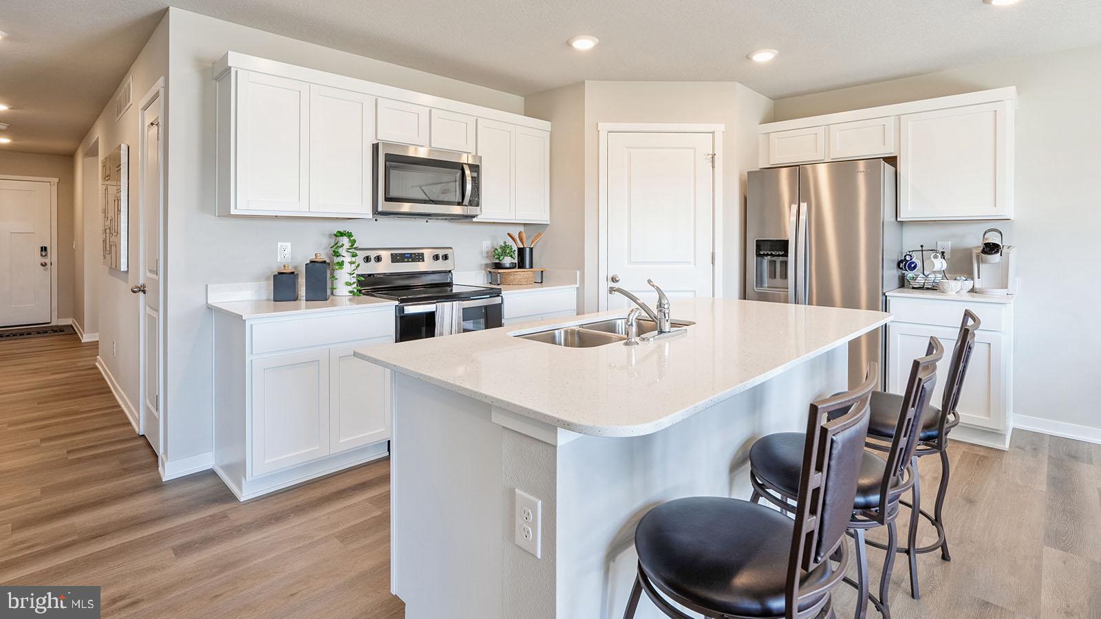 116 Erica Lane Columbia, PA 17512 - Photo 2 of 8 a kitchen with stainless steel appliances a table chairs microwave and refrigerator