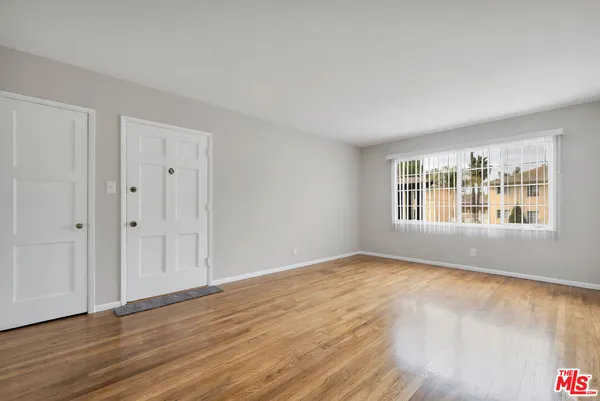an empty room with windows and fan