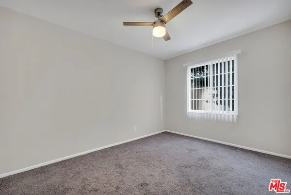 an empty room with a empty space and a ceiling fan