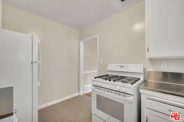 a kitchen with cabinets and a refrigerator