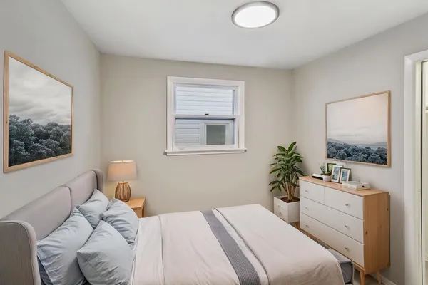 a bedroom with a bed and a potted plant