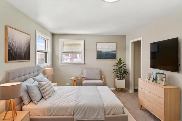 a bedroom with a large bed and a flat screen tv