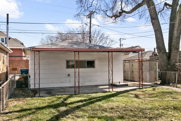 a view of a house with a small yard and large tree