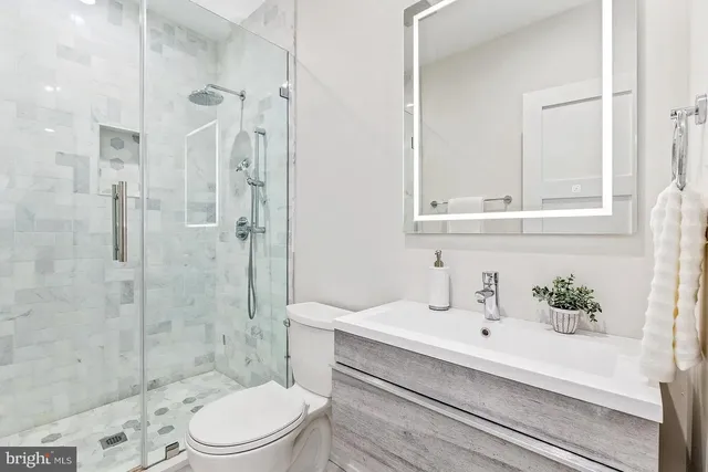 a bathroom with a sink a toilet and shower