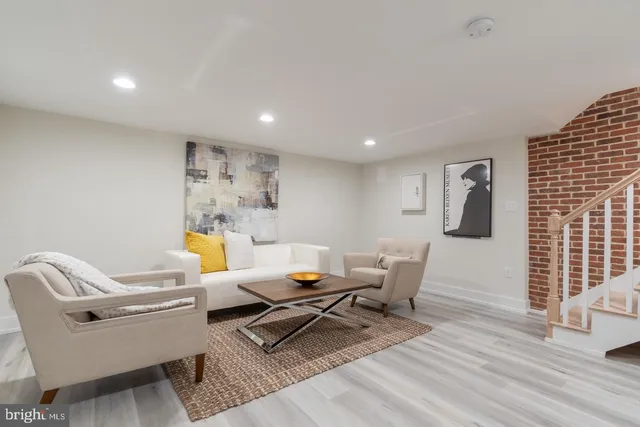a living room with furniture a rug and wooden floor