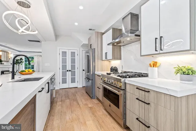 a kitchen with stainless steel appliances a stove a sink and a refrigerator