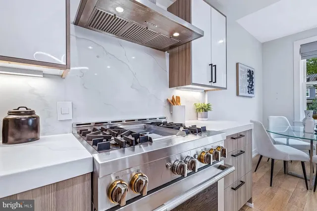 a kitchen with stainless steel appliances granite countertop a stove a sink and a refrigerator