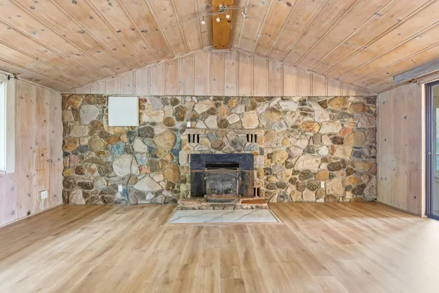 a view of empty room with wooden floor and fireplace