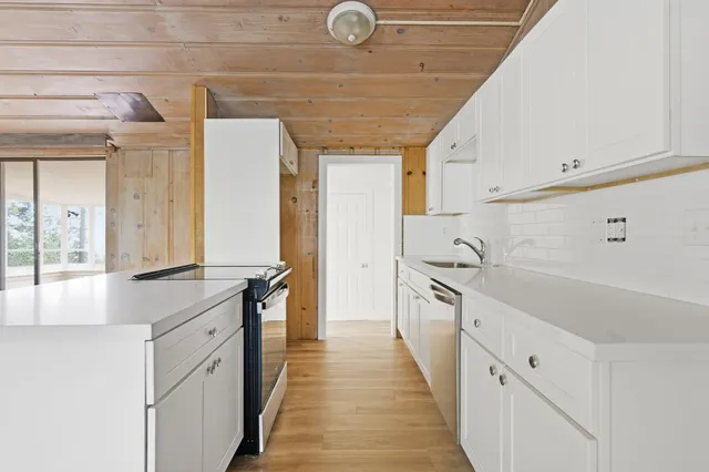 a large white kitchen with a large window