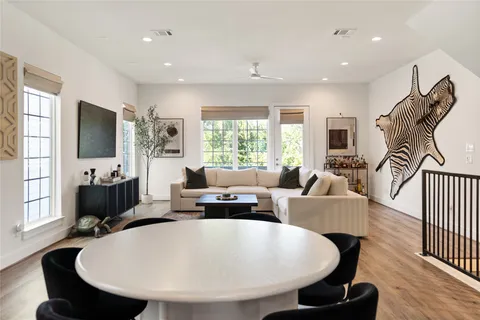 a living room with furniture a flat screen tv and a large window