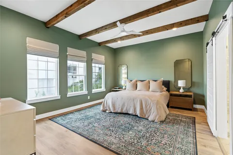 a spacious bedroom with a bed lamp and a large window