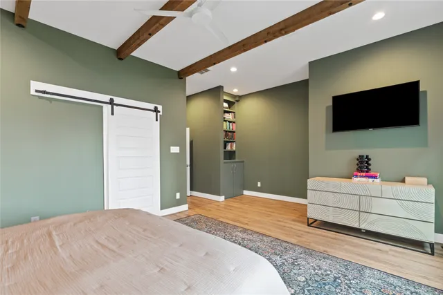 a bedroom with a bed and a flat screen tv