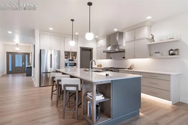 a kitchen with stainless steel appliances kitchen island granite countertop a table chairs and a refrigerator