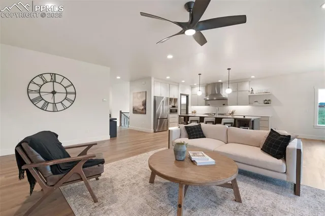 a living room with furniture kitchen view and a chandelier