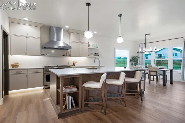 a kitchen with a table chairs stove and wooden floor