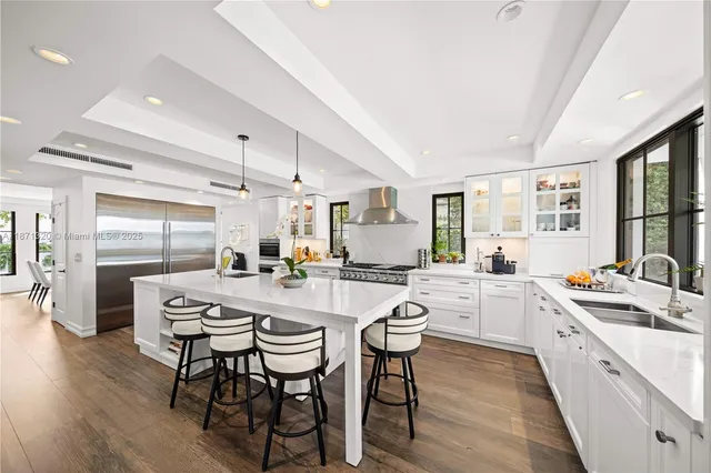 a kitchen with stainless steel appliances granite countertop a stove top oven a sink and a refrigerator