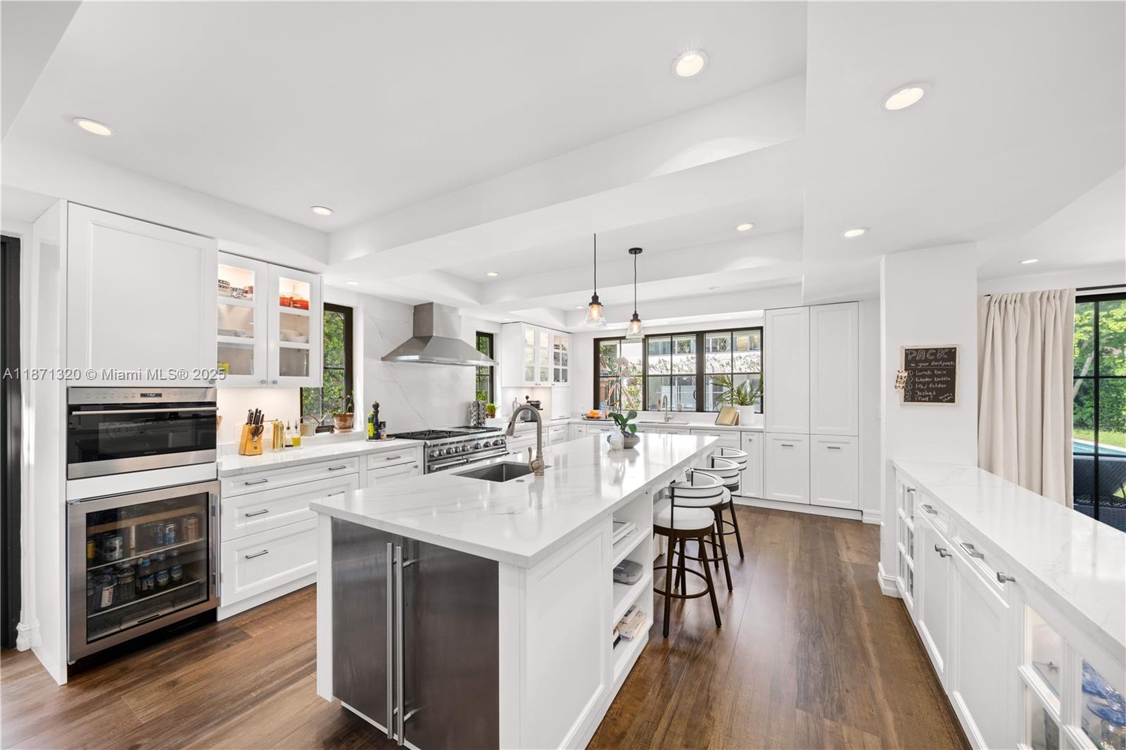 5728 Pine Tree Drive Miami Beach, FL 33140 - Photo 12 of 49 a kitchen with stainless steel appliances granite countertop a stove top oven a sink and a refrigerator