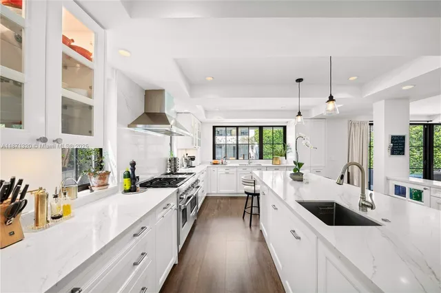 a kitchen that has a lot of cabinets in it and wooden floors