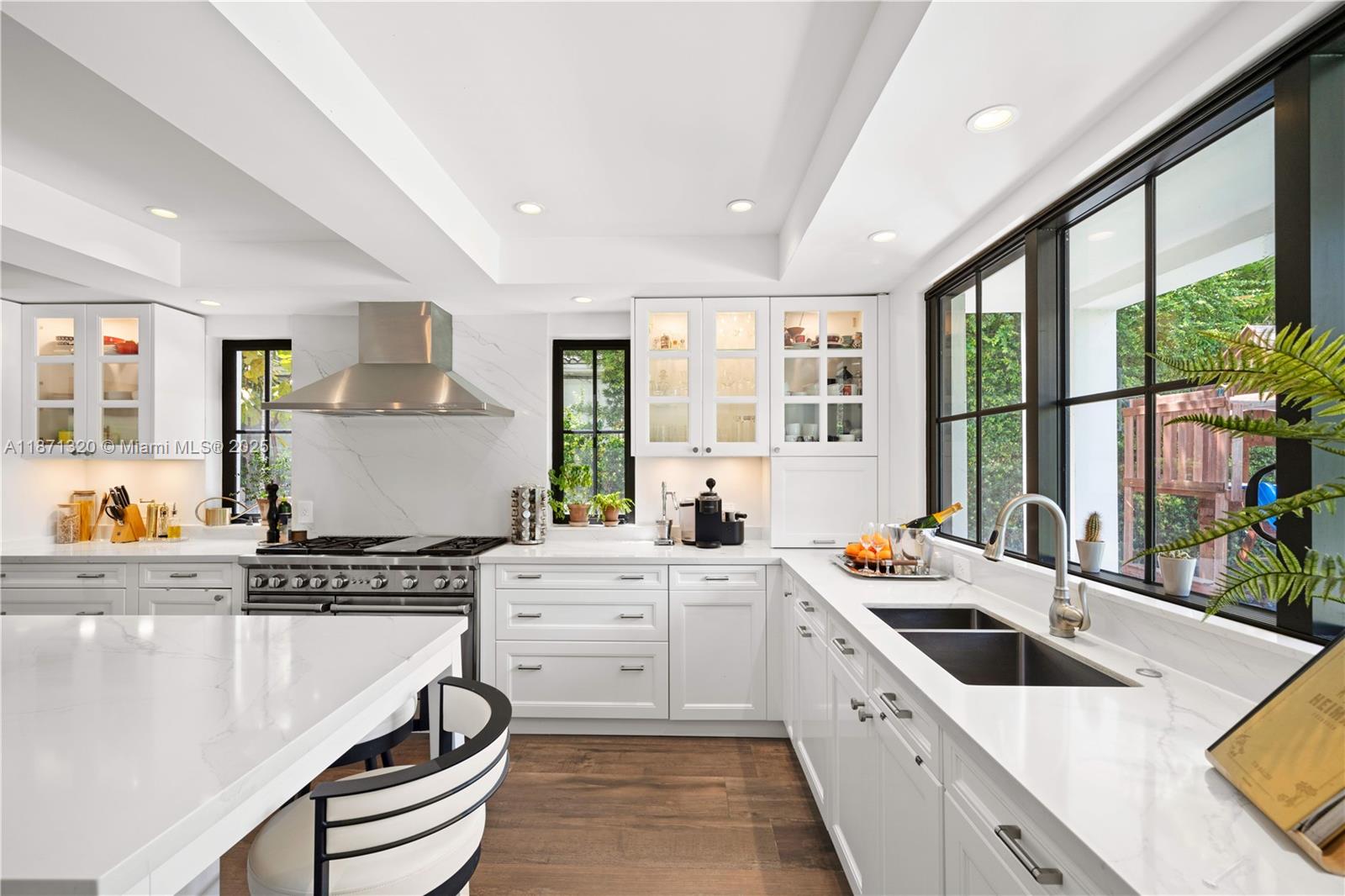 5728 Pine Tree Drive Miami Beach, FL 33140 - Photo 14 of 49 a kitchen that has a lot of cabinets in it and wooden floors